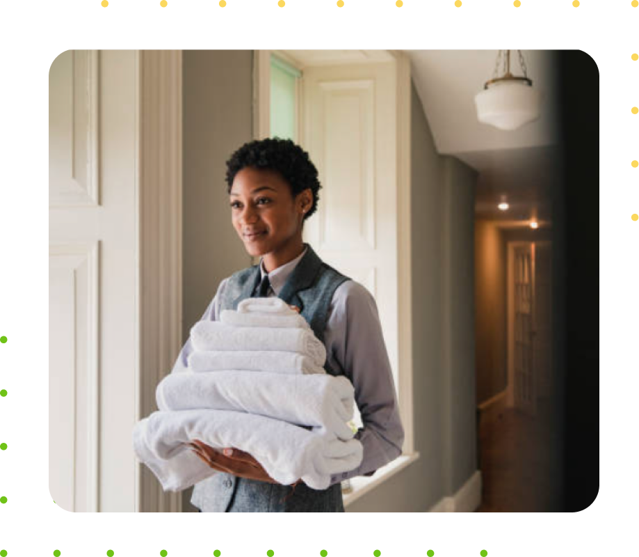 Black woman holding clean white towels in a hotel. Houston Commercial Laundry Service